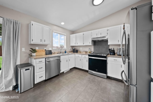 6340 E Choctaw Ct, Sun Valley, NV 89433 - kitchen featuring appliances with stainless steel finishes, under cabinet range hood, vaulted ceiling, white cabinetry, and light countertops