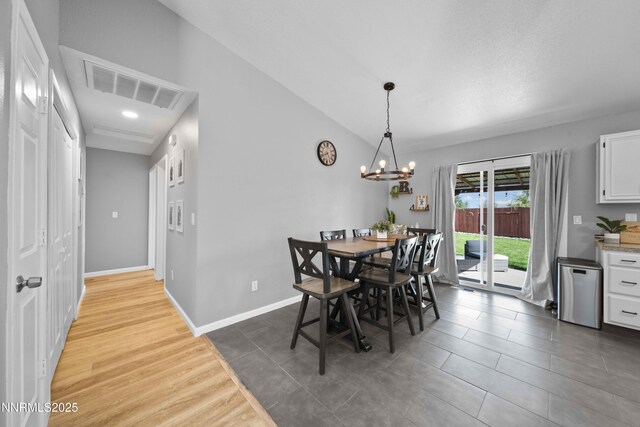 6340 E Choctaw Ct, Sun Valley, NV 89433 - dining area featuring a chandelier, tile patterned floors, and lofted ceiling