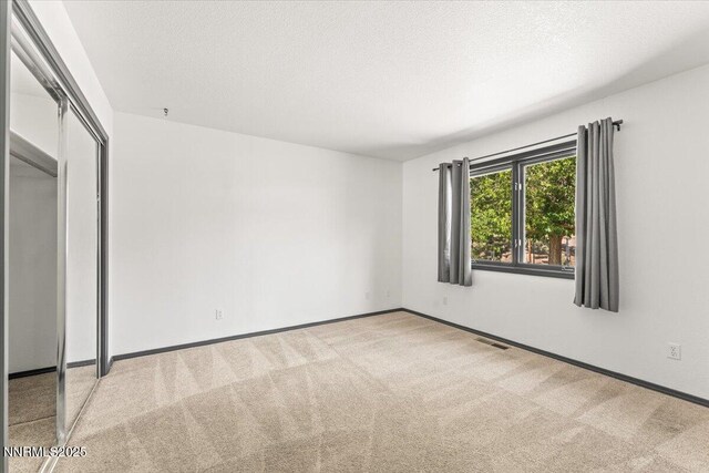 5455 Wild Horse Rd, Reno, NV 89510 - unfurnished bedroom with carpet, a closet, and a textured ceiling