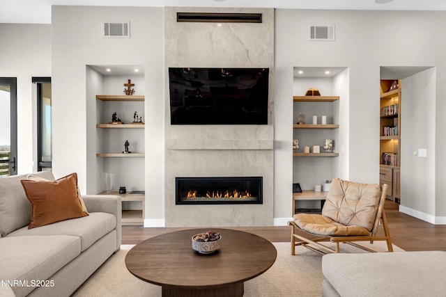 66 Caballada St, Reno, NV 89511 - living room with a tile fireplace, built in features, and wood finished floors