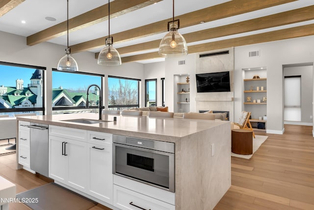 66 Caballada St, Reno, NV 89511 - kitchen with open floor plan, a fireplace, light wood finished floors, light stone counters, and a kitchen island with sink