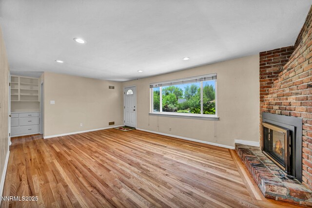 825 W 11th St, Reno, NV 89503 - unfurnished living room with light wood-type flooring, a brick fireplace, and recessed lighting
