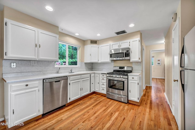 825 W 11th St, Reno, NV 89503 - kitchen featuring stainless steel appliances, white cabinets, light countertops, decorative backsplash, and recessed lighting