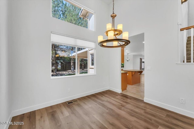 4413 Desert Hills Ct, Sparks, NV 89436 - unfurnished dining area featuring a chandelier, a high ceiling, and wood finished floors