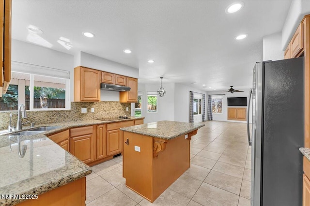4413 Desert Hills Ct, Sparks, NV 89436 - kitchen with freestanding refrigerator, a center island, black electric cooktop, healthy amount of natural light, and recessed lighting