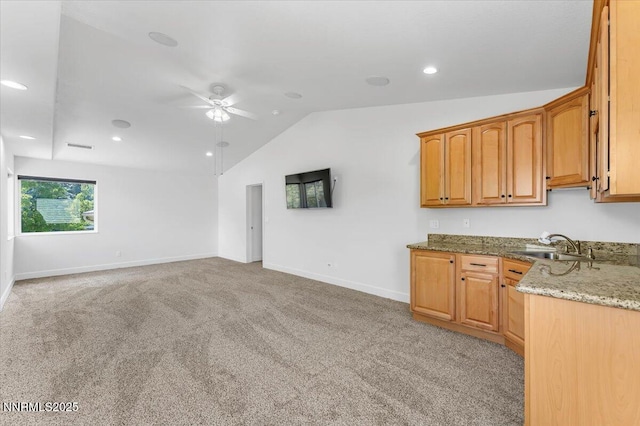 4413 Desert Hills Ct, Sparks, NV 89436 - kitchen featuring lofted ceiling, stone counters, a ceiling fan, light colored carpet, and recessed lighting