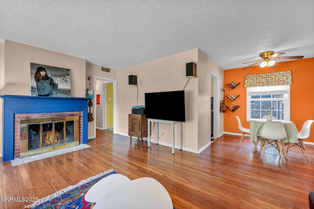 1725 Westfield Ave, Reno, NV 89509 - living area with a textured ceiling, a ceiling fan, wood finished floors, and a brick fireplace