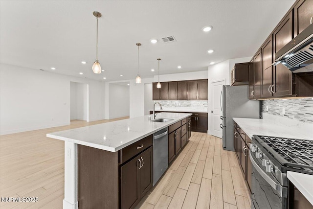 2251 Slater Mill Dr, Sparks, NV 89441 - kitchen featuring appliances with stainless steel finishes, exhaust hood, light wood-style floors, tasteful backsplash, and recessed lighting