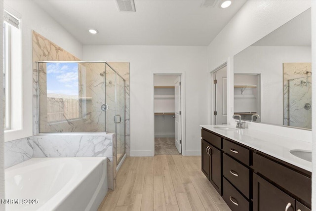 2251 Slater Mill Dr, Sparks, NV 89441 - bathroom with a garden tub, a marble finish shower, a spacious closet, and wood finished floors