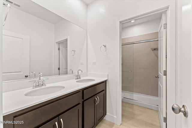 2251 Slater Mill Dr, Sparks, NV 89441 - bathroom with double vanity, tiled shower, and wood finished floors