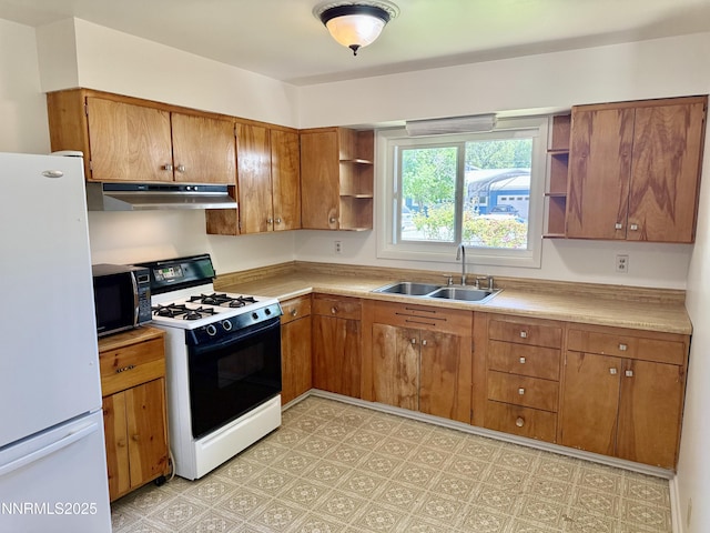 1685 Elmhurst Ave, Lovelock, NV 89419 - kitchen with gas range oven, freestanding refrigerator, open shelves, under cabinet range hood, and black microwave