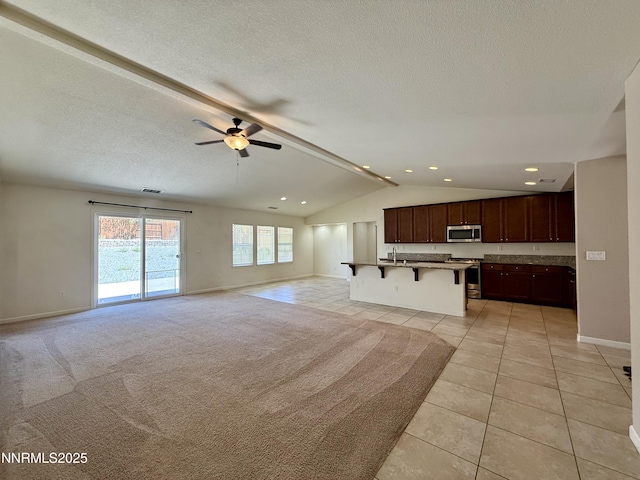 1122 Ferretto Pkwy, Dayton, NV 89403 - unfurnished living room with vaulted ceiling, light tile patterned floors, ceiling fan, and a textured ceiling