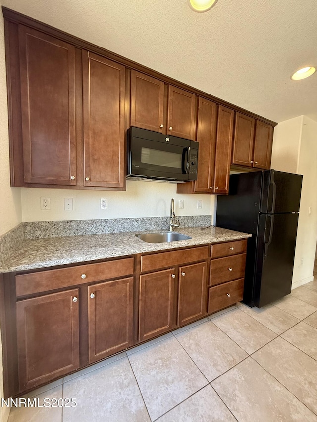 1122 Ferretto Pkwy, Dayton, NV 89403 - kitchen with black appliances, light tile patterned floors, and a textured ceiling