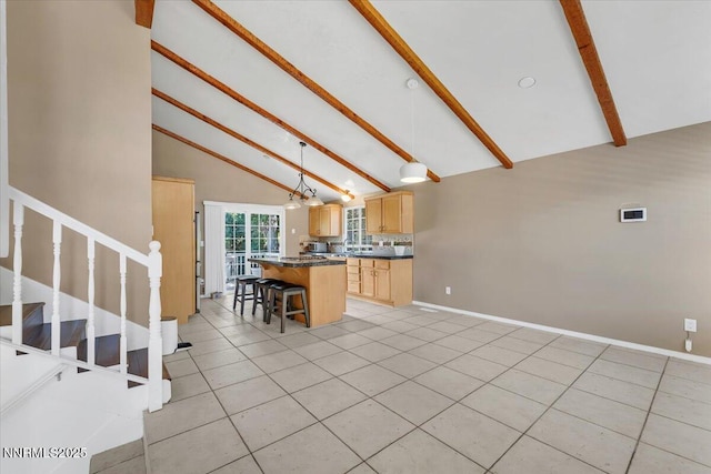 1782 Driftwood Dr, Sparks, NV 89431 - kitchen with light brown cabinets, beam ceiling, dark countertops, a center island, and light tile patterned flooring