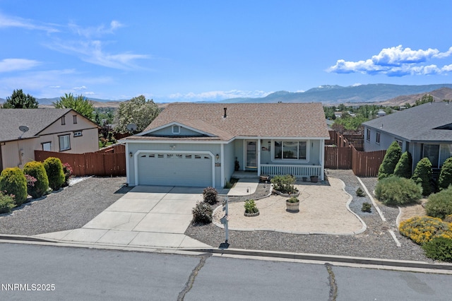7358 Rubens Ct, Sun Valley, NV 89433 - ranch-style house featuring a mountain view, an attached garage, driveway, and covered porch