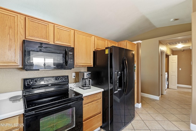 7358 Rubens Ct, Sun Valley, NV 89433 - kitchen featuring black appliances, light tile patterned floors, washer / clothes dryer, vaulted ceiling, and light countertops