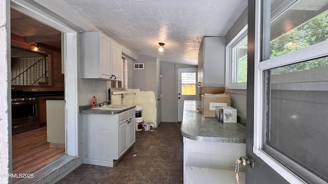 157 Cottonwood Dr, Stateline, NV 89449 - kitchen featuring stainless steel gas range oven, white cabinets, backsplash, and a textured ceiling