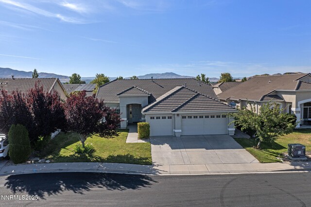 10265 Donnay Ct, Reno, NV 89521 - view of front of home featuring a garage, driveway, stucco siding, and a tiled roof