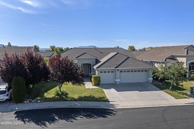 10265 Donnay Ct, Reno, NV 89521 - view of front of property with an attached garage, concrete driveway, a tile roof, a front yard, and stucco siding
