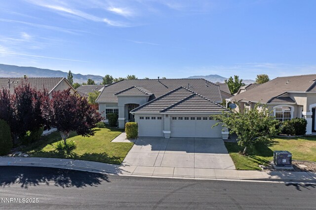 10265 Donnay Ct, Reno, NV 89521 - traditional-style home featuring a garage, concrete driveway, a mountain view, a tiled roof, and a front lawn