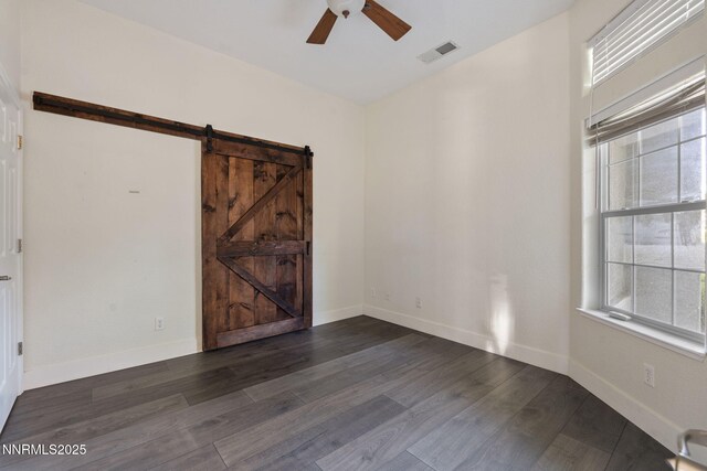 10265 Donnay Ct, Reno, NV 89521 - empty room featuring a barn door, ceiling fan, healthy amount of natural light, and wood finished floors