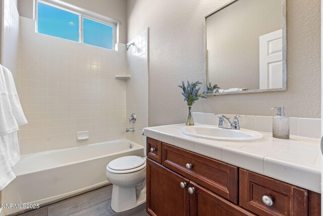 10265 Donnay Ct, Reno, NV 89521 - full bathroom featuring vanity, wood finished floors, shower / tub combination, and a textured wall