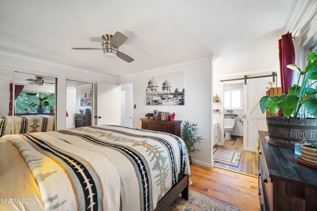 1165 Autumn Hills Dr, Reno, NV 89511 - bedroom with a barn door, light wood finished floors, crown molding, connected bathroom, and ceiling fan