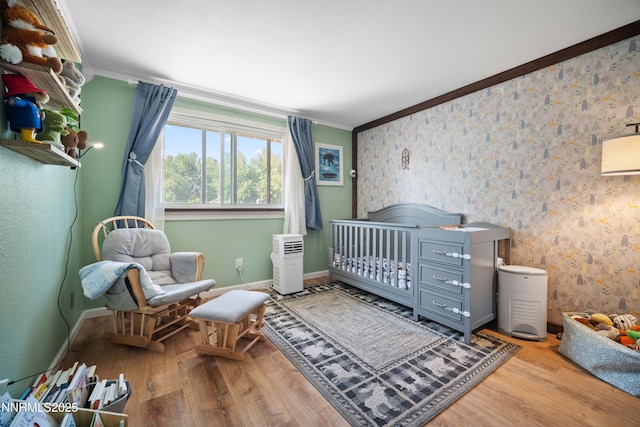 1165 Autumn Hills Dr, Reno, NV 89511 - bedroom with ornamental molding, wood finished floors, a nursery area, and wallpapered walls