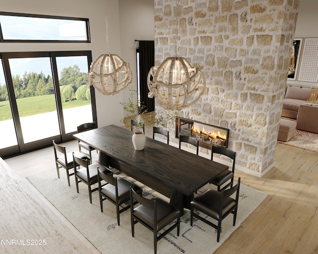 6832 Rabbit Brush Ct, Reno, NV 89511 - dining area with healthy amount of natural light, wood finished floors, a stone fireplace, and a chandelier