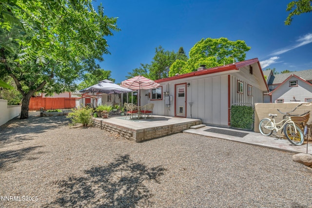 80 Strawberry Ln, Reno, NV 89509 - rear view of house featuring board and batten siding, a patio, a fenced backyard, and a storage unit