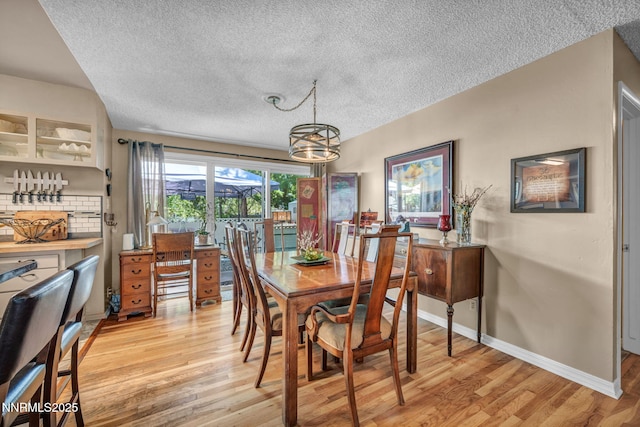 80 Strawberry Ln, Reno, NV 89509 - dining area featuring light wood-style flooring, a textured ceiling, and a chandelier