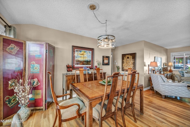 80 Strawberry Ln, Reno, NV 89509 - dining area featuring light wood-type flooring, a textured ceiling, and a chandelier