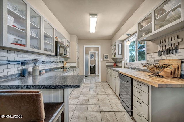 80 Strawberry Ln, Reno, NV 89509 - kitchen featuring black appliances, tasteful backsplash, wooden counters, glass insert cabinets, and open shelves