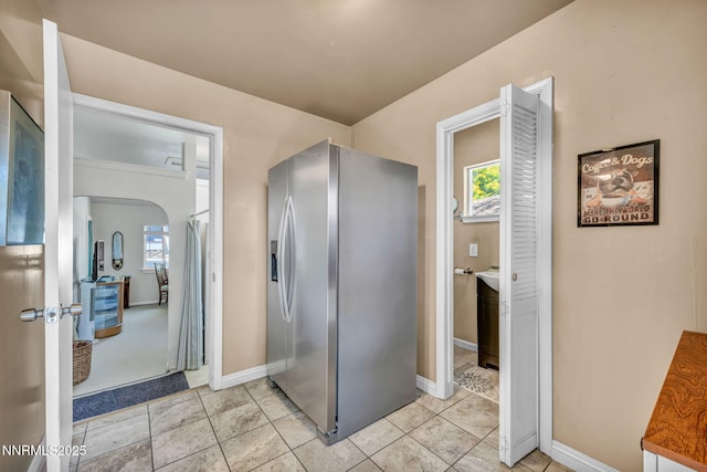 80 Strawberry Ln, Reno, NV 89509 - kitchen featuring stainless steel fridge with ice dispenser, healthy amount of natural light, arched walkways, and light tile patterned floors