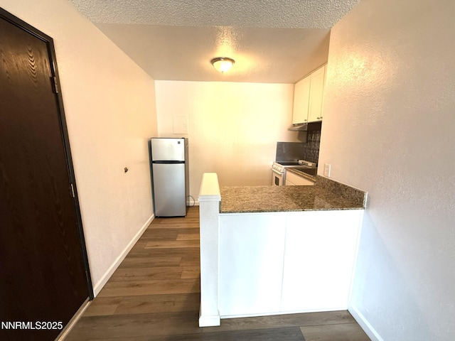 2450 Lymbery St Unit 228, Reno, NV 89509 - kitchen featuring stainless steel appliances, a peninsula, white cabinets, dark wood finished floors, and a textured ceiling