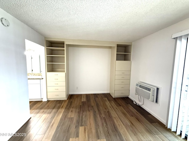 2450 Lymbery St Unit 228, Reno, NV 89509 - unfurnished bedroom featuring a wall mounted air conditioner, wood finished floors, and a textured ceiling