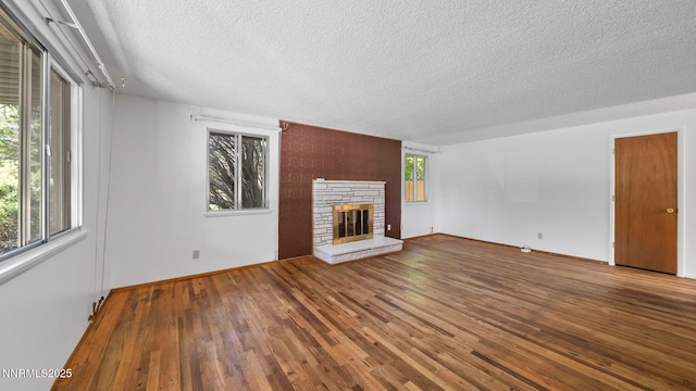 908 E Robinson St, Carson City, NV 89701 - unfurnished living room featuring a textured ceiling, wood finished floors, and a stone fireplace