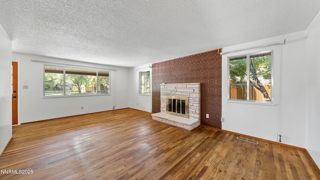 908 E Robinson St, Carson City, NV 89701 - unfurnished living room featuring wood finished floors, a textured ceiling, and a fireplace