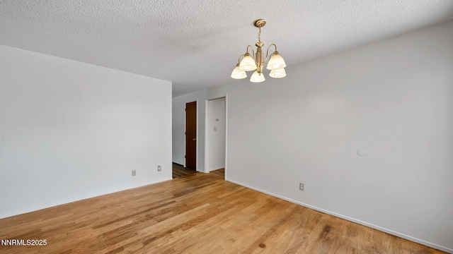 908 E Robinson St, Carson City, NV 89701 - spare room with a chandelier, light wood finished floors, and a textured ceiling
