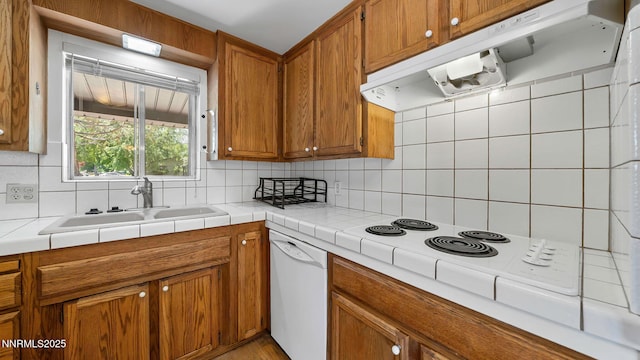 908 E Robinson St, Carson City, NV 89701 - kitchen featuring white appliances, exhaust hood, tasteful backsplash, and brown cabinetry