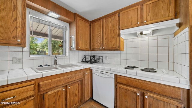 908 E Robinson St, Carson City, NV 89701 - kitchen featuring white dishwasher, under cabinet range hood, backsplash, and brown cabinetry