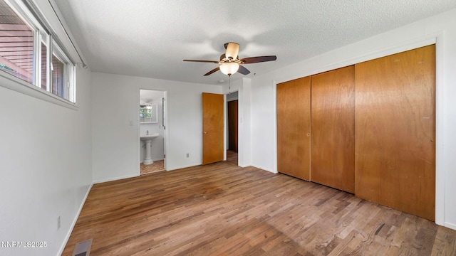 908 E Robinson St, Carson City, NV 89701 - unfurnished bedroom featuring wood finished floors, a closet, a textured ceiling, ensuite bath, and ceiling fan