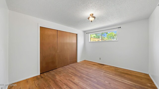 908 E Robinson St, Carson City, NV 89701 - unfurnished bedroom featuring wood finished floors, a closet, and a textured ceiling