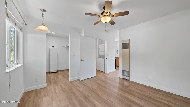 908 E Robinson St, Carson City, NV 89701 - unfurnished bedroom with a heating unit, light wood-style flooring, and stacked washer and clothes dryer