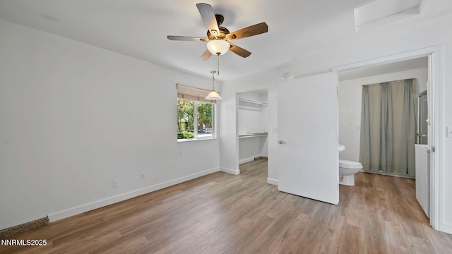 908 E Robinson St, Carson City, NV 89701 - unfurnished bedroom with light wood-style flooring, a spacious closet, a closet, ceiling fan, and connected bathroom