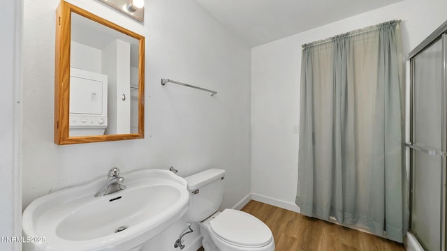 908 E Robinson St, Carson City, NV 89701 - bathroom featuring stacked washer and clothes dryer, a shower with curtain, and wood finished floors