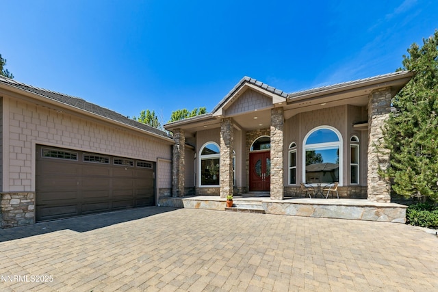 2548 Genoa Aspen Dr, Genoa, NV 89411 - view of front facade featuring stone siding, decorative driveway, and a garage