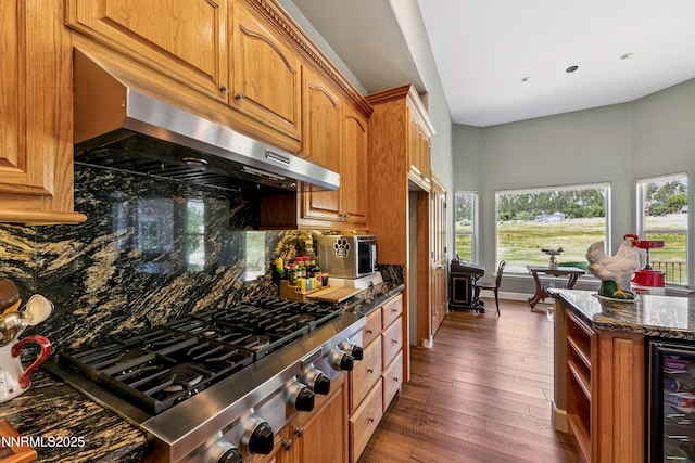 2548 Genoa Aspen Dr, Genoa, NV 89411 - kitchen with wine cooler, exhaust hood, stainless steel gas cooktop, dark stone countertops, and backsplash