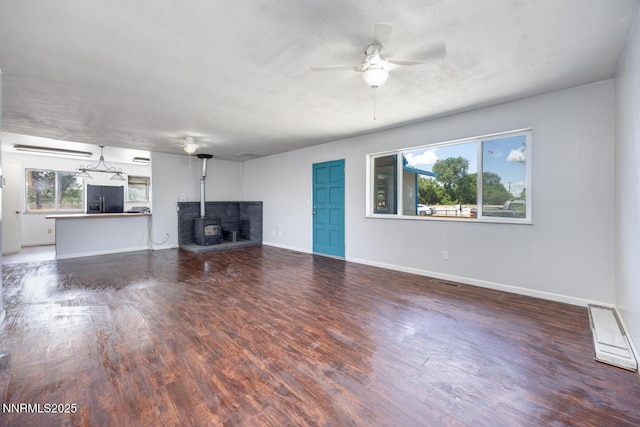 1021 Whitaker Ln, Fallon, NV 89406 - unfurnished living room with ceiling fan, wood finished floors, and a wood stove