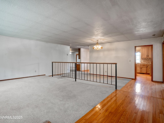1561 Alba Vis, Gardnerville, NV 89410 - spare room with a chandelier, a textured ceiling, and light wood finished floors